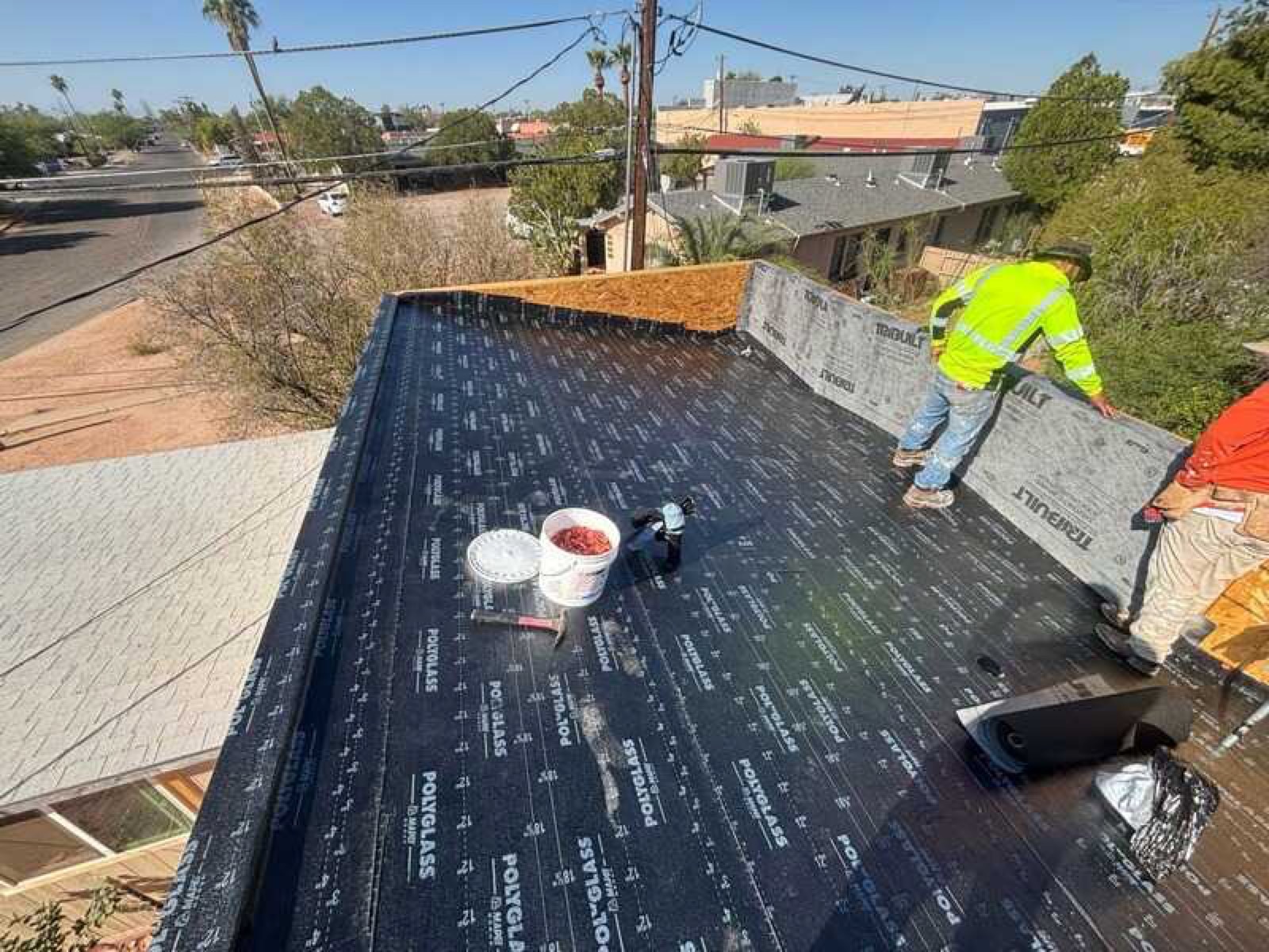 Roofing crew installing roof tiles under the Tucson sky
